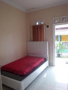 małą sypialnię z łóżkiem z czerwoną pościelą w obiekcie wisma wayang ajen syariah w mieście Cisalak