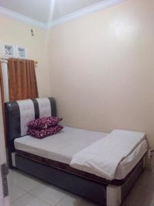 a small bedroom with a bed with at wisma wayang ajen syariah in Cisalak