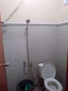 a small bathroom with a toilet and a shower at wisma wayang ajen syariah in Cisalak