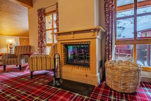 a living room with a fireplace and two chairs at Arc 1950, Hameau du Glacier, Dernier étage , 63m2 , 5m de hauteur sous plafond dans le séjour, Cheminée, Balcon Sud, Piscine, ski aux pieds in Bourg-Saint-Maurice