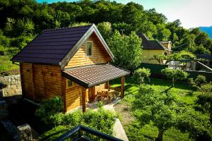 uma pequena cabana de madeira com um telhado num quintal em Green Field Apartments em Virpazar
