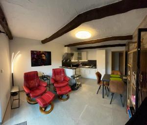 - un salon avec des chaises rouges et une table dans l'établissement Gîte La Gernelle, à Bouillon