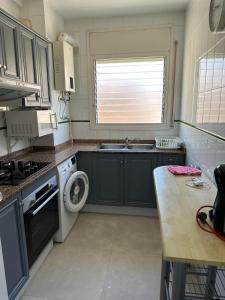 una pequeña cocina con fregadero y lavadora en Playa y confort en Segur de Calafell, en Segur de Calafell