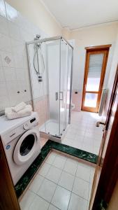 ein Bad mit einer Dusche und einer Waschmaschine in der Unterkunft Vesuvè house in Terzigno
