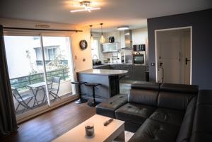 Una sala de estar con un sofá y una cocina. en F2 Vaires sur marne, en Vaires-sur-Marne
