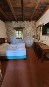 1 dormitorio con cama, mesa y escritorio en Cascina Belvedì, en Clanezzo