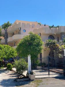 a large building with a tree in front of it at Violit Apartments&Restaurant in Sutomore