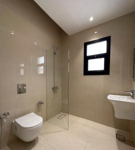a bathroom with a toilet and a shower and a sink at fin apartment C6 in Riyadh +19 photos