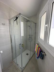 y baño con ducha y puerta de cristal. en Playa y confort en Segur de Calafell, en Segur de Calafell