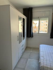 1 dormitorio con 1 cama y vestidor con espejo en Playa y confort en Segur de Calafell, en Segur de Calafell
