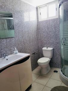 a bathroom with a toilet and a sink and a shower at Sand, Water & Sun House in Vila Nova De Cacela +13 photos