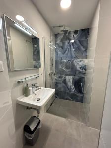 biała łazienka z umywalką i prysznicem w obiekcie Apartments Emilija w Breli