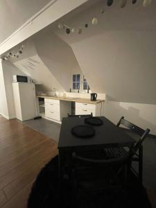 een kamer met een tafel en een keuken op een zolder bij Appartement proche de Paris et l aeroport in Sevran