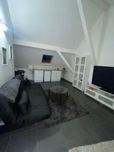 een woonkamer met een bed en een flatscreen-tv bij Appartement proche de Paris et l aeroport in Sevran