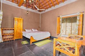 Un dormitorio con una cama y una mesa. en Jungleaashiyana, en Matkuli