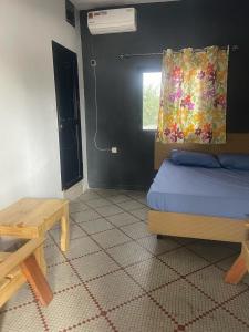 Schlafzimmer mit einem Bett, einem Tisch und einem Fenster in der Unterkunft Auberge-Cafe Tunisie in Nouakchott