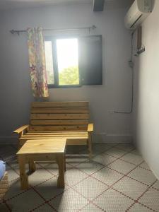 drewniana ławka w pokoju z oknem w obiekcie Auberge-Cafe Tunisie w mieście Nawakszut