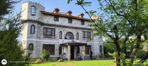 um homem parado em frente a uma casa de pedra em The Citadel em Srinagar