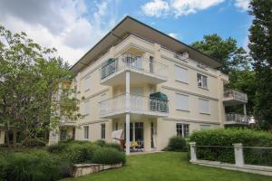 ein weißes Gebäude mit Balkon und Hof in der Unterkunft Villa Charlotte App.13 in Heringsdorf