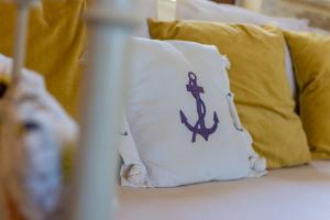 a pillow with an anchor on it sitting on a bed at Villa Clio -St George Retreat BY APOKORONAS VILLAS in Kókkinon Khoríon