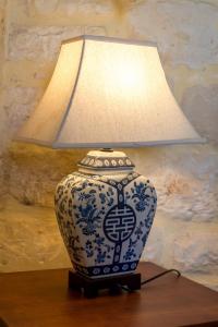 un vaso blu e bianco con una lampada sul tavolo di Villa Clio -St George Retreat BY APOKORONAS VILLAS a Kókkinon Khoríon