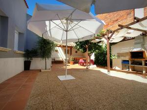 a large white umbrella sitting on a patio at Casa Rural El Caño in Nava del Rey