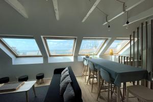 ein Wohnzimmer mit einem Tisch und einigen Fenstern in der Unterkunft Kermorvan - pleine vue mer- parking et wifi - départ pour les îles in Le Conquet