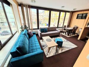 - un salon avec un canapé bleu et une table dans l'établissement Apartment Sarajevo Center Drvenija, à Sarajevo