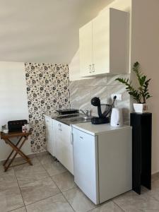 a kitchen with white cabinets and a sink at Apartman Gold lux in Surčin