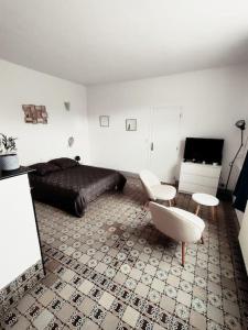 een woonkamer met een bed, een tafel en stoelen bij La ferme des sorciers in Agnez-lès-Duisans