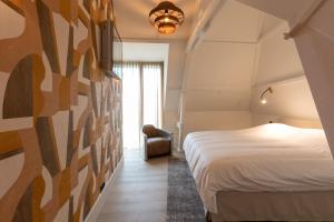 Habitación de hotel con cama y silla en appartement Globo XL, en Middelburg