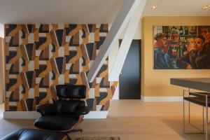 una sala de estar con una silla y una pintura en la pared en appartement Globo XL, en Middelburg