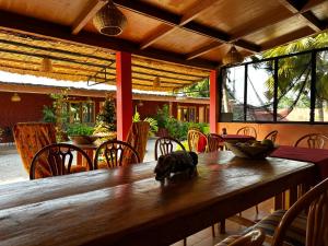 - une salle à manger avec une table et des chaises en bois dans l'établissement Mariama Lodge, à Mbodiène