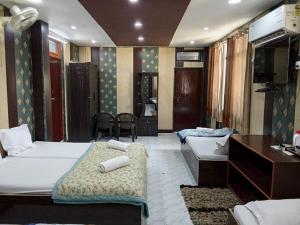 pokój hotelowy z 2 łóżkami i telewizorem w obiekcie Hotel Regard w mieście Waranasi