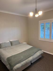 sypialnia z dużym łóżkiem i oknem w obiekcie Family friendly Katoomba Cottage w mieście Katoomba