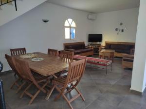 Villa Ulysse Djerba في ميدون: غرفة معيشة مع طاولة وكراسي خشبية