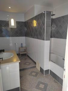 Villa Ulysse Djerba في ميدون: حمام مع حوض وحوض استحمام