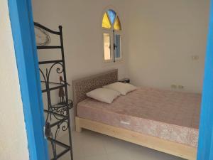 Habitación pequeña con cama y ventana en Villa Ulysse Djerba en Midoun