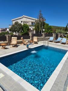 a swimming pool with blue water in a yard at Apartments Mediteran in Ulcinj