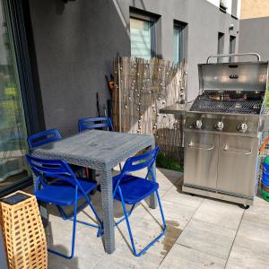 Una mesa y sillas y una parrilla en un patio. en Love Live Łódź z ogrodem, Parking, Grill, en Łódź