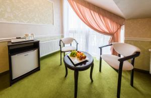 a room with two chairs and a table with fruit on it at Franz Hotel&Restaurant in Ivano-Frankivsk