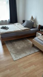 een bed met een houten frame in een kamer met een tapijt bij 2 Zimmer mit Küche und Bad in Bochum