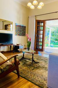 uma sala de estar com uma mesa de centro e uma televisão em Rondeletia Cottage Guesthouse - premium self catering em Gillitts