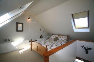 um quarto com uma cama num sótão com uma janela em The Steading em Corrie