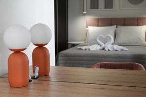 due lampade su un tavolo in una camera da letto con un letto di Mouson House Luxury Apartments a Kavala