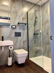 uma casa de banho com um WC e uma cabina de duche em vidro. em The Pines Guest House em Elgin