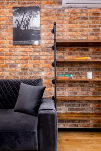 a brick wall with a couch in a room at STAR Apartments Gdańsk - Gym & Sauna in Gdańsk