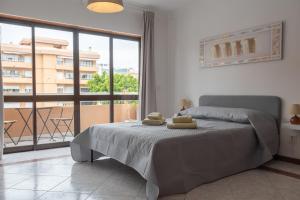 a bedroom with a bed and a large window at Blife Ricardya private rooms in Faro