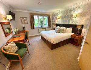 1 dormitorio con cama, escritorio y escritorio en New Forest Lodge en Landford