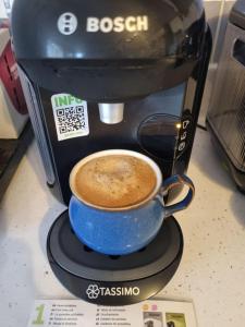 a coffee maker with a blue cup of coffee at Forester's Retreat Glamping - Dinas View in Aberystwyth